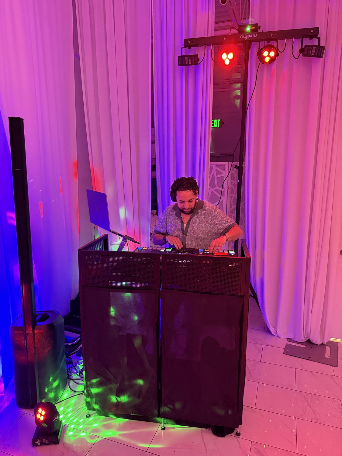DJ LevSev behind the booth with colorful uplighting at a birthday